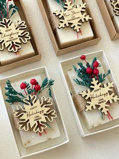 four wooden snowflakes in boxes on a table