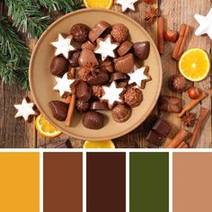 a bowl filled with chocolates next to orange slices and star shaped candies on top of a wooden table