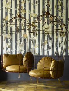 two brown chairs sitting in front of a bird cage