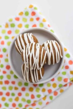 two cookies with white icing are on a plate next to a polka dot napkin