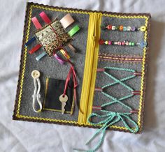 an open book with many different items on top of it, including yarn and scissors