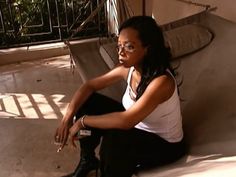 a woman sitting on top of a cement bench