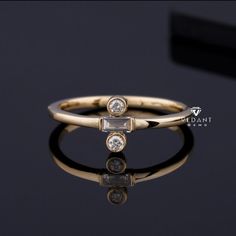 a gold ring with two diamonds on it