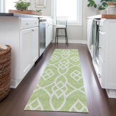 a green rug in the middle of a kitchen