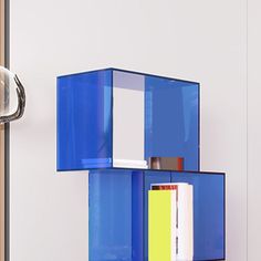 a blue shelf sitting on top of a white wall next to a door handle and bookshelf