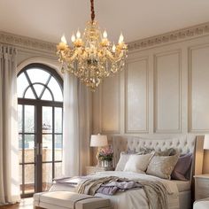 a bedroom with a chandelier hanging from the ceiling and a bed in front of a window