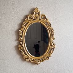 a gold mirror hanging on the wall