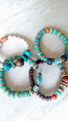 "Spirited, fun, happy, and artisan made. Beautiful bright color in these mixed stack bracelets. Several orange-red lampwork beads in several sizes and colors. Bright Turquoise Howlite and dyed wood, natural coconut disks, clay spacers in brown, ethical bone beads, seafoam sea glass, and gold disks. Unique and colorful. The item/s pictured is the item you will receive. Bracelets is 7.0\" to 7.5\" in length. HavSolStudio on ETSY | Mixed media . Earthy elegance . Great texture . Beach inspired . Co Bohemian Stretch Bracelet With Large Beads For Everyday, Artisan Blue Beaded Bracelets For Beach, Artisan Blue Bracelets For The Beach, Blue Bohemian Beaded Bracelets With Wooden Beads, Bohemian Blue Beaded Bracelets With Wooden Beads, Earthy Turquoise Bracelets For Festival, Bohemian Blue Bracelets With Wooden Beads, Multicolor Bohemian Stacked Bracelets, Bohemian Multicolor Stacked Bracelets