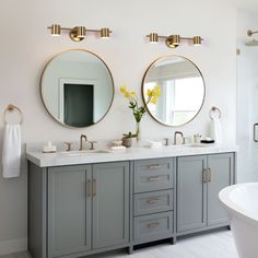 a bathroom with two sinks, mirrors and a bathtub in the middle of it