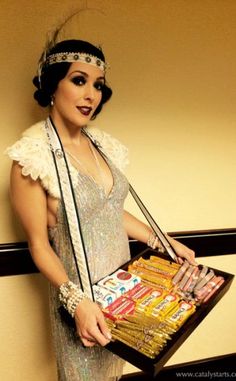 a woman in flap dress holding a box of candy