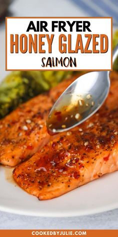 a plate with salmon, broccoli and sauce being drizzled on it