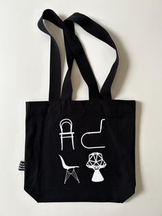 | Description |  Modern Vitra Design Museum black "Atlas of Furniture Design" canvas tote bag.  Tote is black with chair graphic on one side and black straps.  Great for everyday use or grocery shopping!  Bag is in excellent condition with light wear.  There are no holes or tears.  Side has "Vitra Design Museum" tag. | Approximate Size | tote: 15" W x 14" H x 3 3/4" D x 13"L straps | Disclaimer | Please read the description and review photos thoroughly, as all sales are final.  Please read shop policies for full details.  Please message me with any additional questions.  All items are used/vintage and have wear consistent with age. Black Travel Bag With Graphic Print, Black Cotton Canvas Bag With Adjustable Strap, Black Canvas Tote Bag For Daily Use, Black Canvas Shoulder Bag For Daily Life, Black Tote Canvas Bag For Daily Use, Black Tote Canvas Bag For Daily Life, Black Rectangular Canvas Bag With Graphic Print, Black Graphic Print Canvas Tote Bag, Black Canvas Tote Bag With Graphic Print