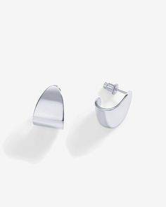 Trendy and chic, these 16mm long and 12mm wide earrings feature an abstract design, making a bold statement. Lightweight and chunky, these hoops offer an elegant blend of sophistication and modern style.Materials 14K yellow gold or white gold plated. s925 Sterling Silver Posts. Measurements: Length: 16mm; Width: 12mm. Hypoallergenic; nickel, lead, and cadmium free. Abstract Design, Modern Style, Gold Plate, Hoop Earrings, Plating, Yellow Gold, White Gold, Sterling Silver, Yellow