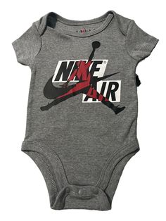 This Nike Air Jordan one-piece is the perfect addition to your little one's wardrobe. With a stylish gray color and classic sports theme, it's suitable for travel, activewear, and casual occasions. The bodysuit features snap closure and a crew neckline, made of a comfortable cotton and polyester blended fabric, ensuring easy care and all-seasons wear. The short-sleeved bodysuit is ideal for summer, fall, and spring, and it comes in size 6 months, suitable for unisex babies and toddlers. The Nike logo is accentuated on the bodysuit, making it a trendy outfit for your little one. The description of this one-piece does not include the word "condition" to avoid repetition in the item description. Baby Jordan Outfits, Nike Baby Clothes, Boy Onesies, Baby Jordans, Jordan Shorts, Baby Boy Clothes Newborn, Jordan Outfits, Baby Boy Onesies, Short Sleeve Bodysuit