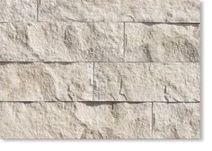 a white stone wall that has been made from different types of stones and is very high quality