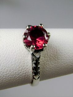 Simulated Red Ruby Ring Wedding #D22 This is a Victorian Era solitaire ring. This lovely sterling silver wedding solitaire has an approximately .5 carat simulated red ruby gemstone. This full cut flawless gemstone is 6mm (1/4") in diameter. The inside of the band is marked 925 for sterling silver. Notice the beautiful crown design of the silver filigree setting and the etched band. This is a lovely rendition of an Antique filigree ring. Classically fashioned, this ring is a vintage wedding style Classic Promise Ring With Lab-created Ruby, Classic Lab-created Ruby Rings For Promise, Classic Red Promise Ring, Classic Ruby Ring For Promise With Prong Setting, Classic Ruby Birthstone Promise Ring, Round Cut Ruby Promise Ring With Center Stone, Ruby Birthstone Ring For Anniversary, Classic Red Birthstone Ring With Prong Setting, Red Classic Birthstone Ring With Prong Setting