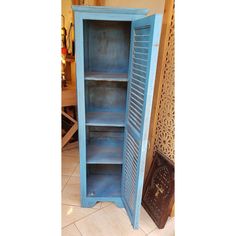 a blue bookcase sitting on top of a tiled floor