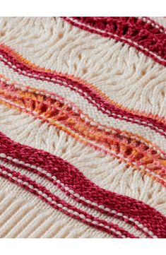 a red and white rug with different colored lines on the bottom, along with an orange stripe in the middle