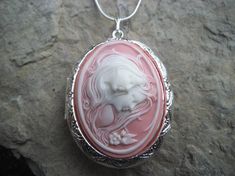 Beautiful cameo locket!!!  The cameo is beautifully detailed!!!  Wonderful gift for sisters, mothers, daughters, and friends!!!! The locket is victorian style with beautiful scroll on the front and back about 1 3/4" long.  It can hold two photos, keepsakes, or even your daily medication or vitamins!!! Pass down from generation to generation!!! The chain is 22"  1.2mm .925 plated snake chain with a lobster claw clasp!!! Perfect  for Brides or Bridal parties.  Makes a unique memorable gift for any Cameo Medallion Locket Necklace Keepsake, Cameo Medallion Locket Necklace For Keepsake, Elegant Cameo Keepsake Jewelry, Elegant Cameo Jewelry Keepsake, Elegant Cameo Locket Necklace For Wedding, Keepsake Medallion Locket Necklace With Cameo, Pink Necklaces With Intricate Design For Gift, Vintage Cameo Locket Necklace For Wedding, Antique Cameo Jewelry For Keepsake