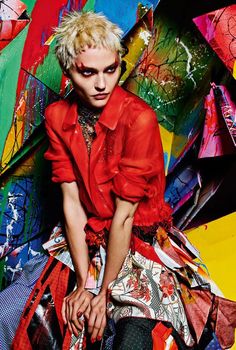 a woman sitting on top of a pile of colorful kites in front of her