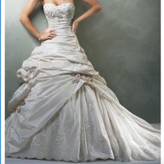 a woman in a white wedding dress posing for a photo with her hands on her hips