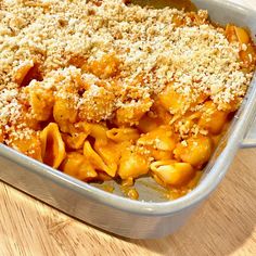 a casserole dish with pasta and cheese in it on a wooden table top