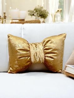 a gold bow pillow on a white couch