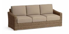 a wicker couch with four cushions on it