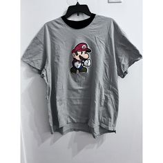 an image of a mario bros t - shirt hanging on a wall