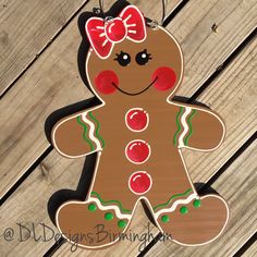 a wooden cutout of a ginger with a red bow on it's head