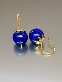 Beautiful vibrant and high-grade lapis lazuli globe earrings. The 12.5 mm lapis lazuli globes have a gorgeous deep vibrant royal blue color that shows celestial flecks of golden pyrite in the stone. The ultra-fine globes attached to a beautiful 14K gold-filled flower caps as they attached the vermeil on sterling ear wires. These are elegant and perfect earrings to go with any outfit. A pair of fine gemstone essentials. *Ball size (diameter): 12.5 mm *Metal: vermeil on sterling *Earrings drop len Round Lapis Lazuli Gemstone Earrings, Elegant Lapis Lazuli Gemstone Earrings, Elegant Lapis Lazuli Earrings With Natural Stones, Gold Earrings With Natural Lapis Lazuli Stones, Blue Lapis Lazuli Earrings For Formal Occasions, Blue Lapis Lazuli Earrings, Pierced Lapis Lazuli Round Jewelry, Royal Blue Lapis Lazuli Round Jewelry, Elegant Lapis Lazuli Earrings For Gift