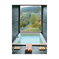 an indoor jacuzzi tub in front of a large window