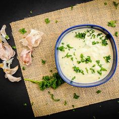 a blue bowl filled with soup sitting on top of a table