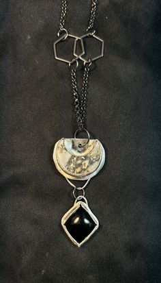 This is a grey Jasper crescent moon complimented by an diamond shaped Obsidian set in sterling silver. It's on a 26" gunmetal rolo chain with hexagon details. Artisan Silver Necklace With Moon Phase, Artisan Silver Necklace With Moon Phase Detail, Artisan Silver Jewelry With Moon Phase, Artisan Silver Crescent Jewelry, Unique Black Jewelry With Moon Phase, Artisan Crescent Silver Jewelry, Unique Black Moon Phase Jewelry, Silver Crescent Necklace With Natural Stones, Black Crescent Metal Jewelry