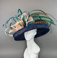 Navy Blue flipped brim hat adorned with peacock spines. Coordinated with shades of teal and turquoise feathers. Fits crown size of 22.5" with internal elastic band to create a snug and comfortable fit for crown sizes smaller than 22.5". Please measure prior to purchasing as all sales are final. Don't forget to follow us on Instagram @ TheHatHive Blue High Crown Hat With Adjustable Fit, Adjustable Brimmed Blue Top Hat, Blue Adjustable Boater Hat With Curved Brim, Adjustable Blue Boater Hat With Curved Brim, Adjustable High Crown Blue Hat, Blue Adjustable High Crown Hat, Adjustable Blue Costume Hats With Curved Brim, Adjustable High Crown Blue Costume Hats And Headpieces, Blue Wide Brim Hat Bands For Kentucky Derby