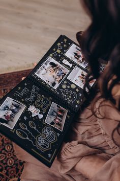 a woman laying on top of a bed next to a black and white photo album