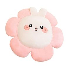 a pink and white flower shaped pillow with eyes on it's face, sitting in front of a white background