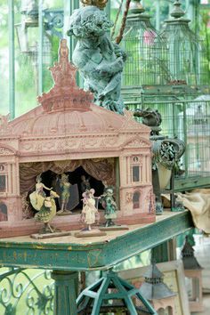 an elaborately decorated birdcage with figurines on it