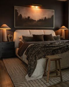 a bedroom with a large painting above the bed and two stools in front of it