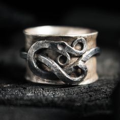 Embrace the mystery of Norse mythology with our Midgard Serpent ring. This handcrafted Viking jewelry features the legendary Jormungandr, the Midgard Serpent. Made from high-quality silver and iron, this Viking ring is durable and exudes a rugged, timeless appeal. - measures 15 mm wide - Band made out of silver and the serpent is forged out of iron (Note: Since it's all handmade shapes may slightly vary) Midgard Serpent, Serpent Ring, Viking Ring, Power Symbol, The 3 Kings, Ring Ideas, Viking Jewelry, Circle Of Life, Norse Mythology