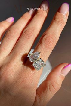 a woman's hand holding a diamond ring