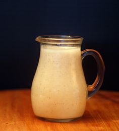 a glass pitcher filled with liquid sitting on top of a wooden table next to the words champagne vinaigrette