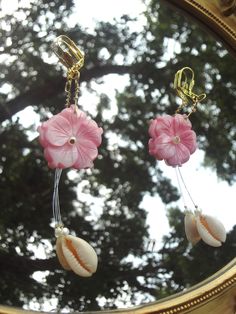 ✧ ೃ༄ Length: ~4.6 in ✧ ೃ༄ Carefully put together with super cute shell carved pink flowers, cowrie shells, tiny pearls, and illusion cord to give the effect of the dangling cowrie shells. ✧ ೃ༄The earring hooks and wire are gold in color. Summer Dangle Jewelry With Flower Decoration, Bohemian Flower Charm Jewelry For Beach, Pink Flower-shaped Jewelry For Vacation, Pink Flower Jewelry For The Beach, Pink Flower Jewelry For Vacation, Pink Flower Jewelry For Beach, Summer Vacation Jewelry With Flower Shape, Summer Flower Jewelry For Vacation, Flower-shaped Summer Vacation Jewelry