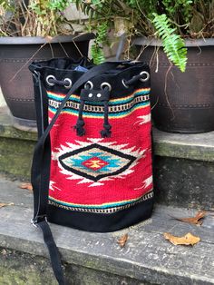 Red and Black woven southwestern bucket bag Southwestern Style Tote Bag For Everyday Use, Artisan Bucket Bag With Adjustable Strap For Travel, Southwestern Style Everyday Tote Bag, Artisan Travel Bucket Bag With Adjustable Strap, Red Bohemian Rectangular Bucket Bag, Bohemian Red Rectangular Bucket Bag, Southwestern Style Bag With Adjustable Strap, Southwestern Style Bags With Adjustable Strap For Everyday Use, Southwestern Style Bag With Adjustable Strap For Everyday Use