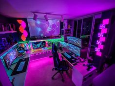 a room filled with lots of computer monitors and desks covered in neon colored lights