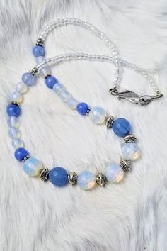 Gorgeous Faceted Opalite Necklace / Faceted Blue Agate / Stone / Gemstone Necklace / Bead Necklace / Silver Beads / Gift For Her This gorgeous Opalite and Faceted Blue Agate necklace is pure beauty.  I call it the Cinderella Necklace. The semi-precious gemstones are accented with silver cone spacer beads.  Glass Japanese Aurora Borealis beads continue the sparkle to the hook and eye clasp giving a smooth and luxurious feeling around the neck. The magic of the opal is hard to capture in the camera lens, but you will see the light capturing beauty of the stones in person.  It measures just a little over 19 inches. I do my best to portray the true colors of the gemstones and most pictures are taken in natural lighting. Some stones, however, are harder to photograph than others and you just ha Blue Agate Polished Bead Necklaces, Blue Agate Beaded Necklace With Polished Beads, Blue Agate Polished Beads Necklace, Blue Agate Beaded Necklaces, Blue Crystal Necklaces With Faceted Beads For Healing, Blue Agate Beaded Necklace, Blue Agate Round Beads Necklace, Blue Faceted Beads Gems And Cabochons For Gift, Blue Faceted Beads For Gifts