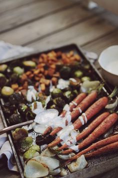 carrots, brussel sprouts and other vegetables on a baking sheet