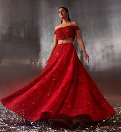 Step into elegance with this Red Sequins Embroidered Bridal Lehenga Set, the epitome of sophistication and grace. Crafted from soft net fabric, the red lehenga is beautifully adorned with intricate tonal dori work, meticulously highlighted with sparkling sequins, shimmering crystals, and delicate bugle beads. Teamed with an off-shoulder blouse, offering a modern twist to the traditional attire, with a flattering silhouette that exudes confidence and poise. The look is completed with a lightweigh