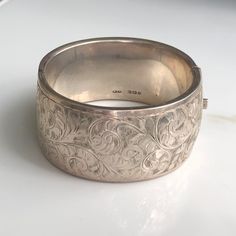 A vintage silver bangle with an ornate floral style. CONDITION: Wear consistent with age and use. Please see photos for more detail. HALLMARKED SILVER, ASSAYED IN BIRMINGHAM  APPROX. INTERNAL SIZE: BANGLE WIDTH: 31mm WEIGHT: 52.1g INTERNAL DIAMETER: 57mm x 52mm (CZ) Silver Bangle Bracelet, Silver Lockets, Silver Bangle Bracelets, Silver Bangle, Coral Turquoise, Silver Cuff Bracelet, Natural Turquoise, Floral Style, Silver Bangles