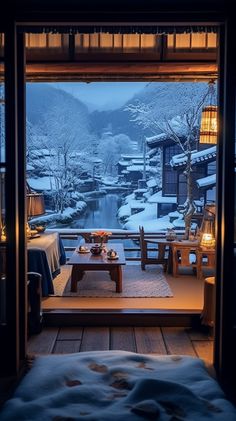 an open door leading to a room with snow on the ground and mountains in the background